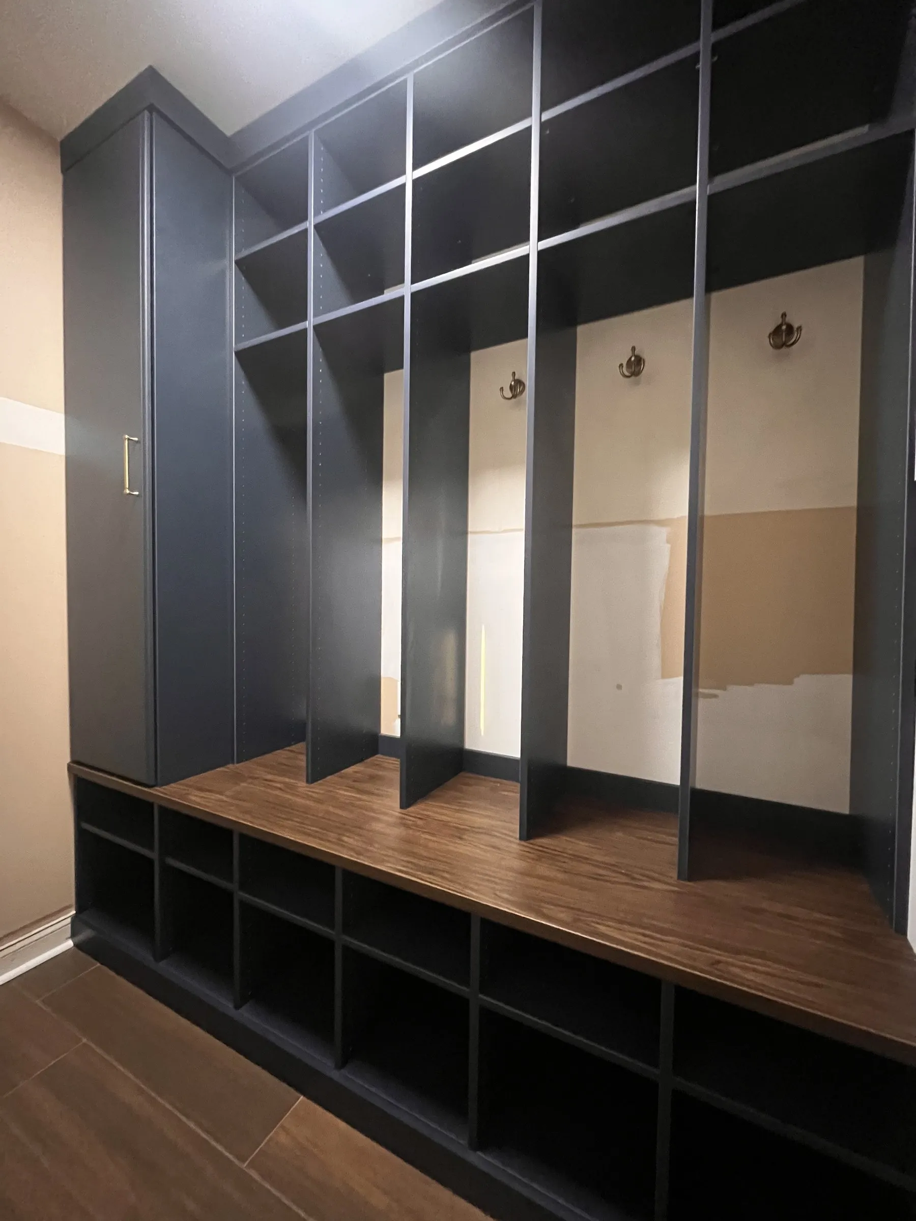 Navy mudroom lockers with a wood bench and open cubbies below
