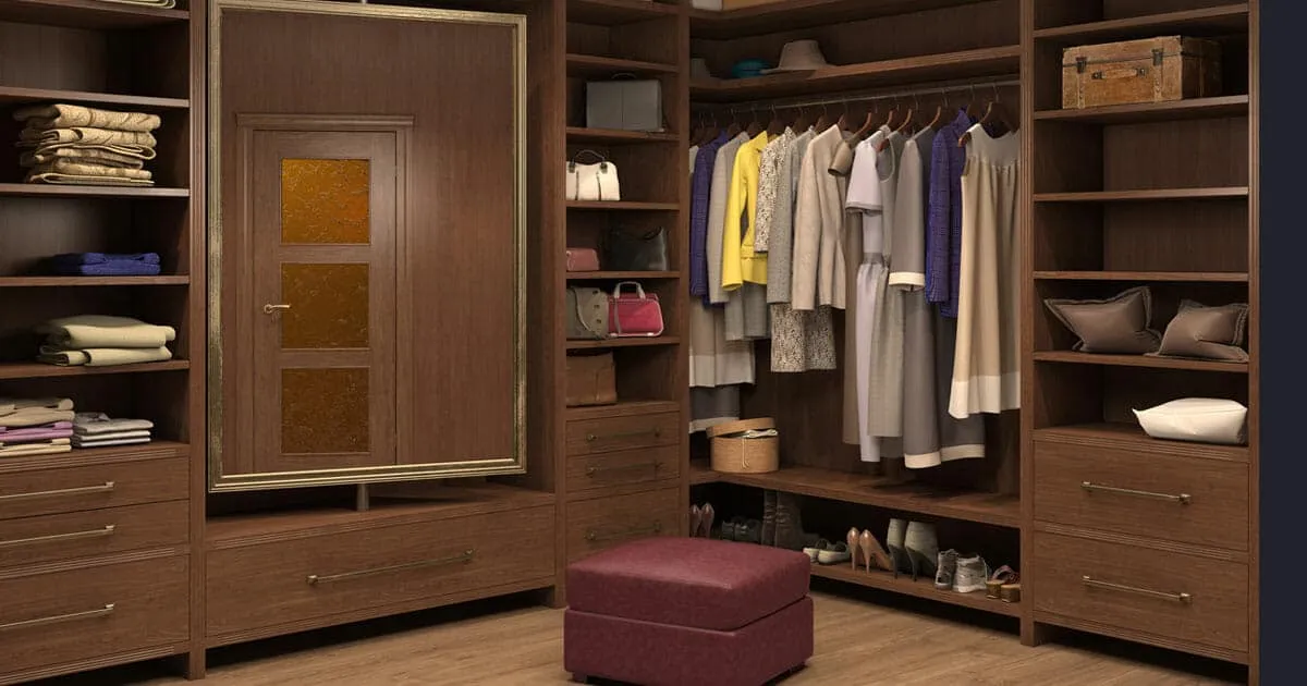 Luxury walk-in closet with dark wood built-in shelving, drawers, and hanging clothes, plus shoe storage and a cushioned ottoman in the center.