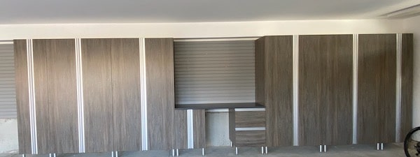 custom designed and installed gray wood look garage storage cabinets with silver feet in Montgomery County, PA residential garage