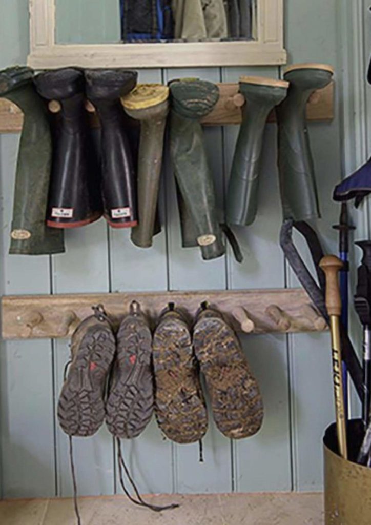 muddy shoes and boots hanging on wall