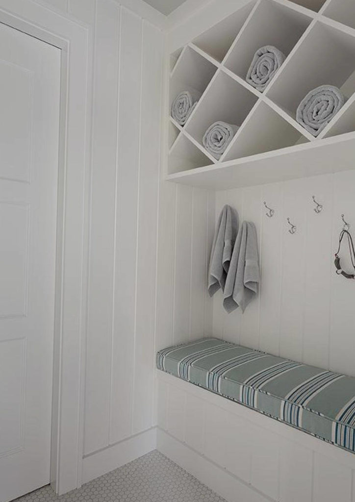 mudroom storage bench with hooks and slanted shelves for towels