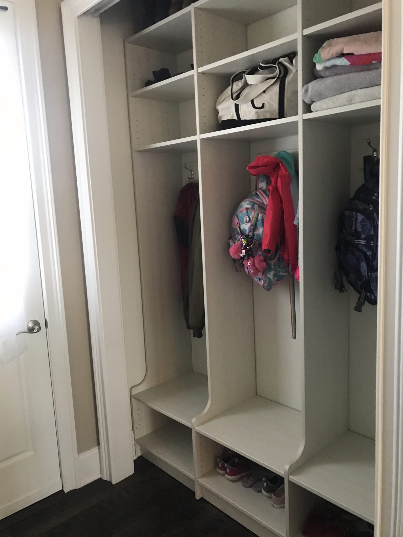 Custom floor-to-ceiling mudroom lockers with closed doors for storage