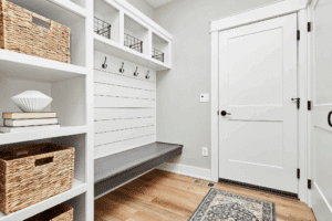A neat, clean, well-lit, and organized mudroom with custom storage cabinets and seating
