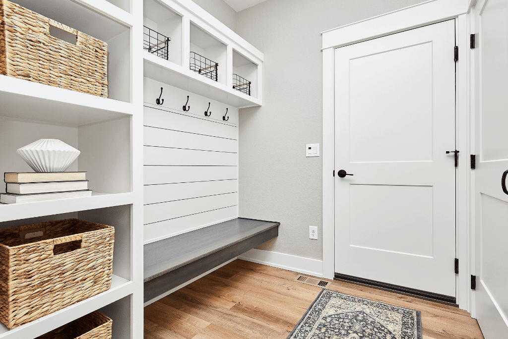 A neat, clean, well-lit, and organized mudroom with custom storage cabinets and seating