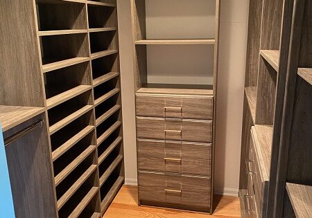 customized walk-in closet storage with coffee brown shelving and drawers in narrow closet